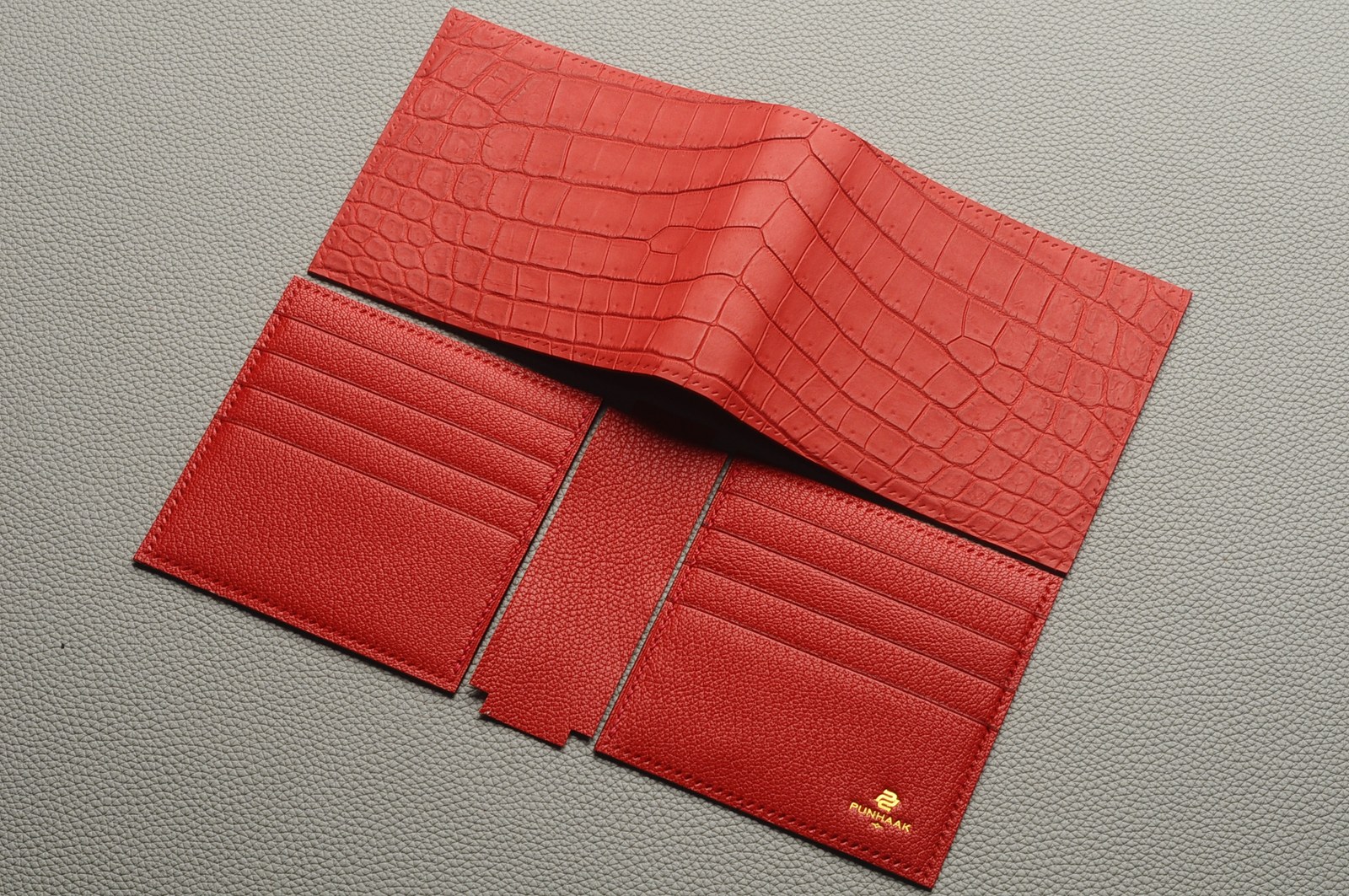 Open red crocodile leather wallet showing card slots and interior construction