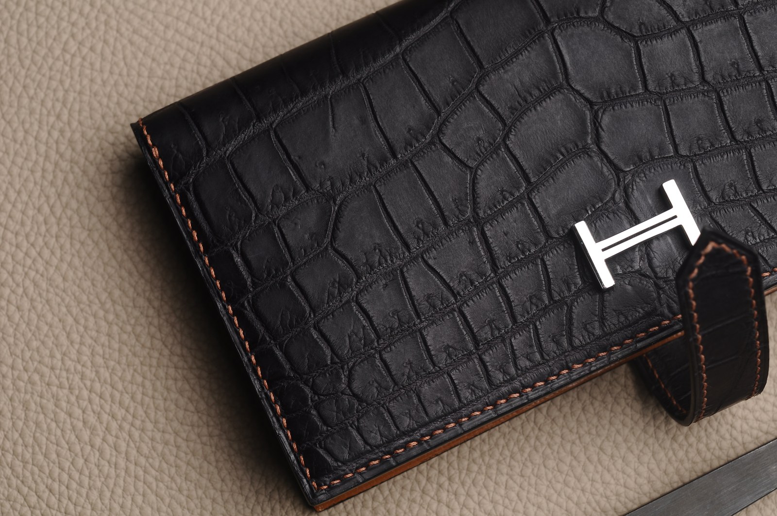 Close view of a metal logo applied to a finished leather piece