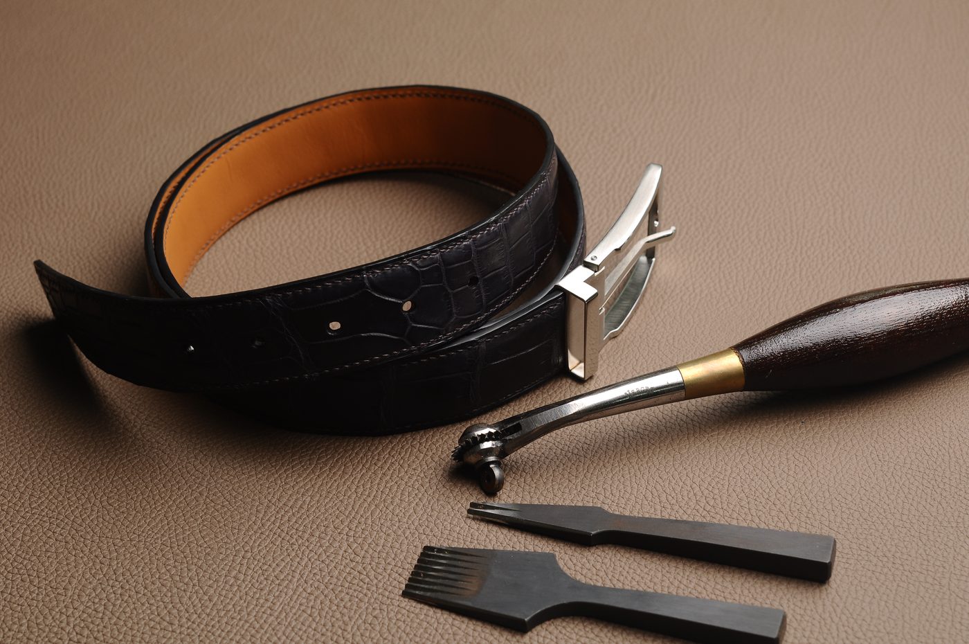 Black leather belt with buckle and leather working tools