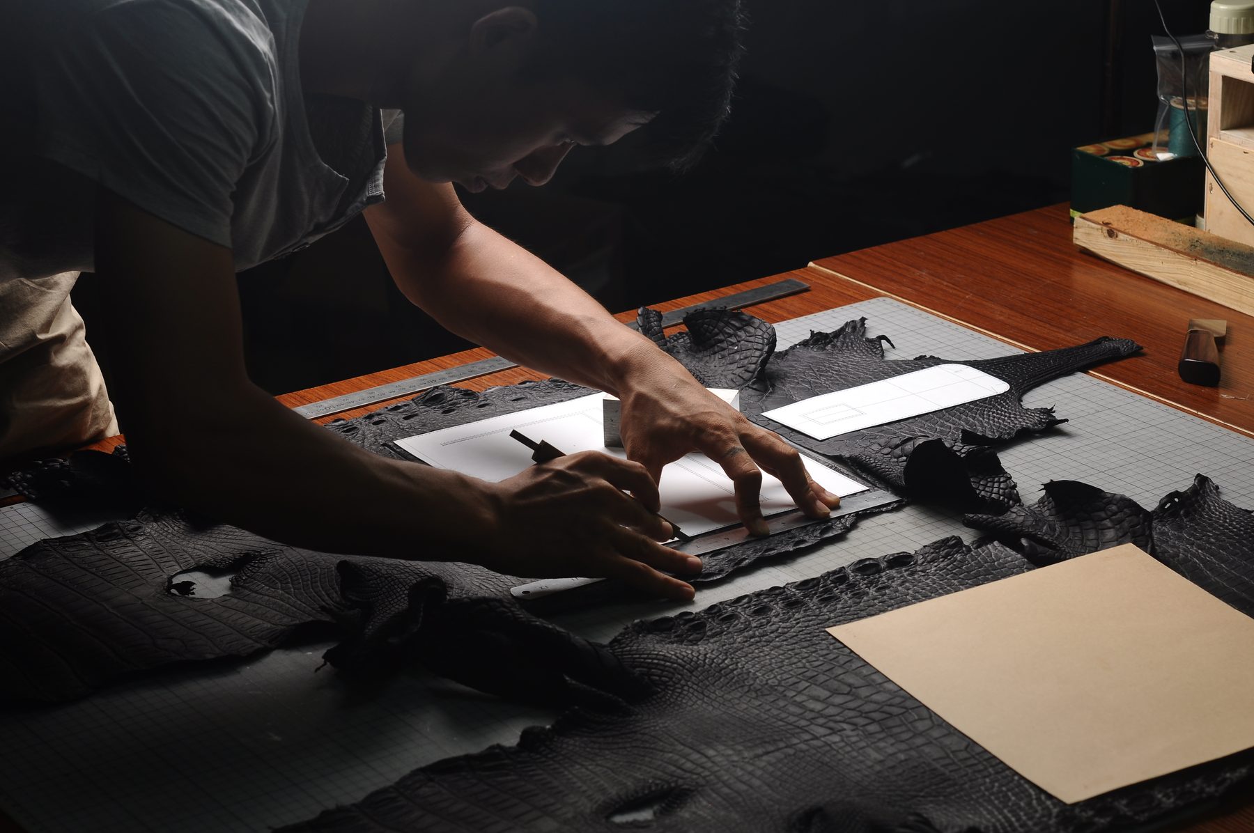 Artisan hand cutting leather pattern in the workshop