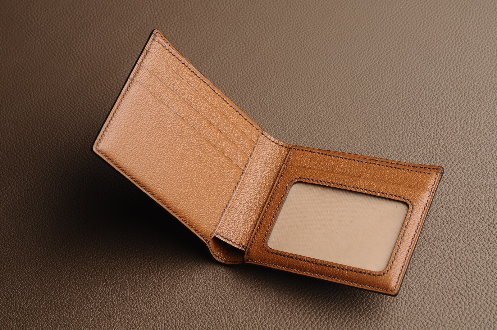 Open brown window wallet showing its framed pocket and construction