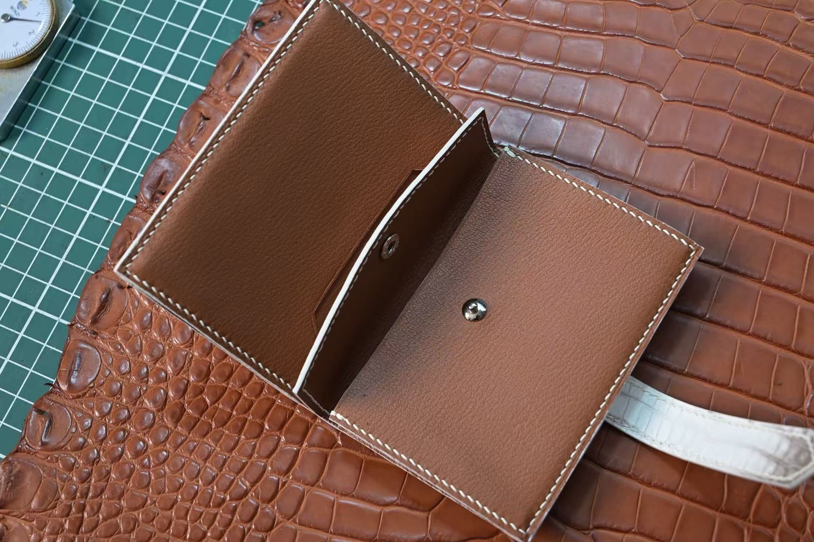 Open two-tone crocodile leather coin purse with snap closure and contrast stitching