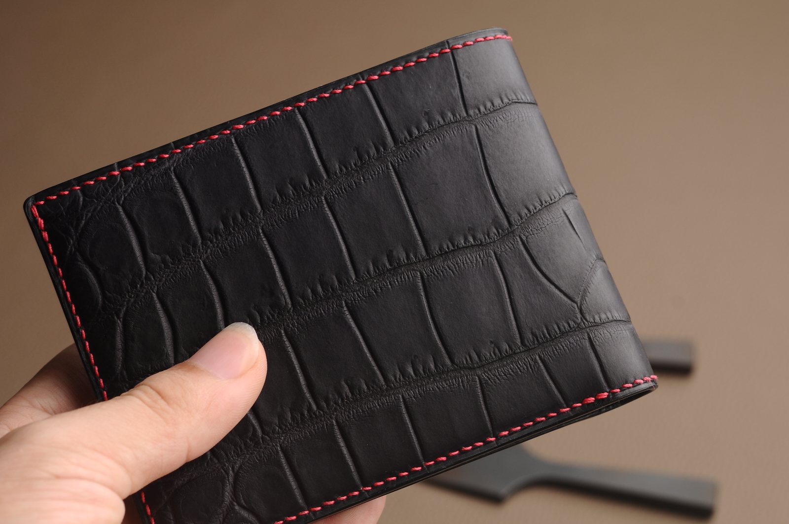 Black wallet exterior detail with red stitching